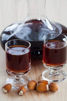 Homemade hazelnut liqueur in a glass carafe on a wooden background