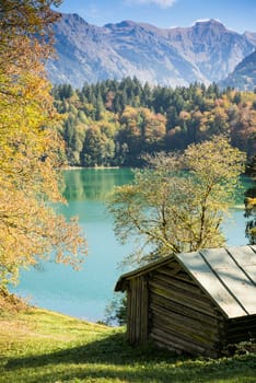 Hut on the lake in autumn in the mountains in portrait format