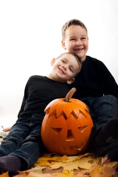 A cute photograph of a two boys and her Halloween pumpkin