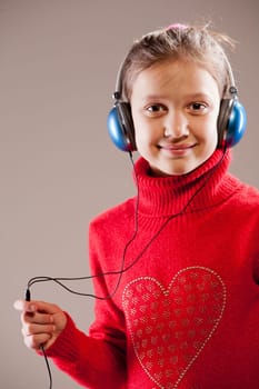 Little girl listening to the music inher blue headphones