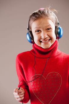Little girl listening to the music inher blue headphones