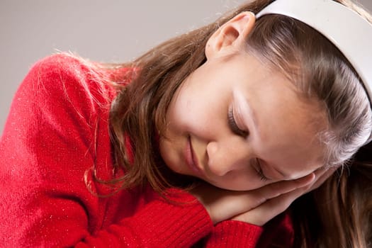 Little girl sleeping with her face on her hands