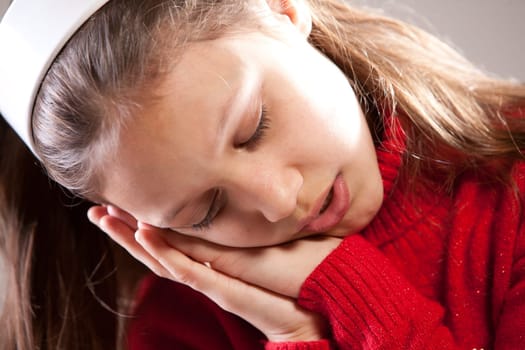 Little girl sleeping with her face on her hands