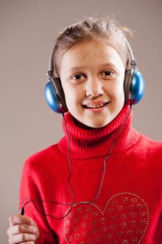 Little girl listening to the music inher blue headphones