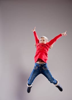 Little girl jumping and dancing happily in the air