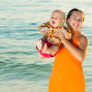 Baby and mother on the tropical beach