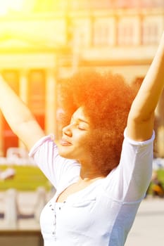 Happy young woman with afro hairstyle in the sun