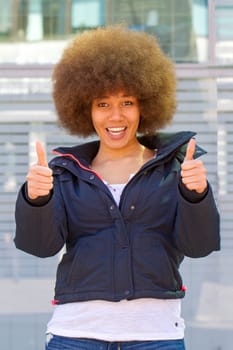 Young woman with afro hairstyle and thumbs up