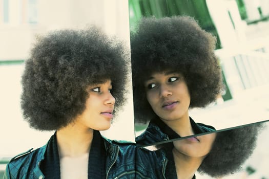 Young dark-skinned woman on a mirror