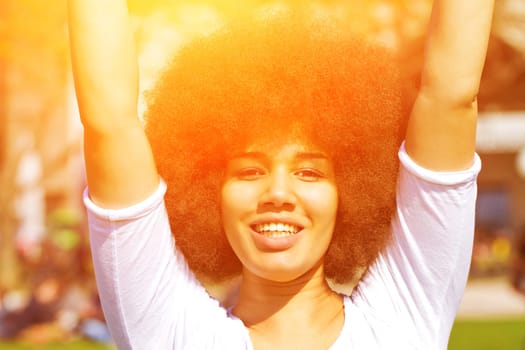 Happy young woman with afro hairstyle in the sun