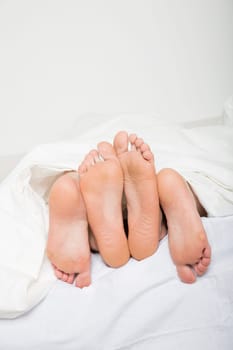 Married couples feet in bed