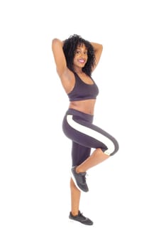 A slime African American woman in black exercise clothing standing in.profile, showing her great figure, isolated for white background..