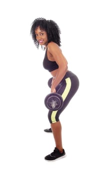 A young pretty African American woman in exercising outfit lifting weight,.standing in profile, isolated for white background..