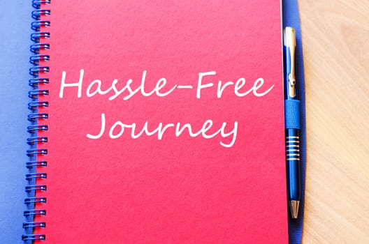 Hassle free journey text concept write on notebook with pen
