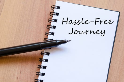 Hassle free journey text concept write on notebook with pen