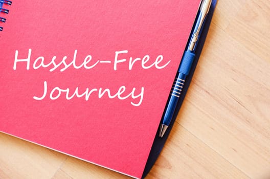 Hassle free journey text concept write on notebook with pen