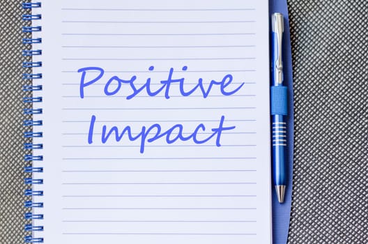 Positive impact text concept write on notebook with pen
