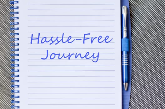 Hassle free journey text concept write on notebook with pen