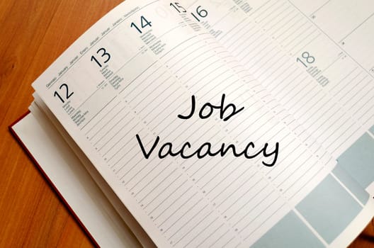 Job vacancy text concept write on notebook with pen