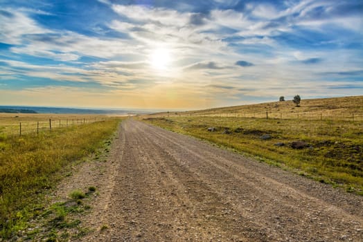 Blue and yellow sunrise over a dirt road near Buffalo, Wyoming