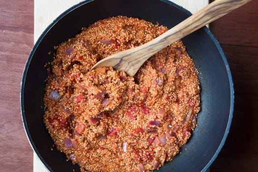 Vegan quinoa Sloppy Joe sauce in a cooking pot with wooden spoon