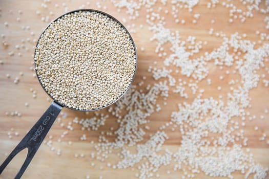 Fresh uncooked quinoa in measuring cup from above.