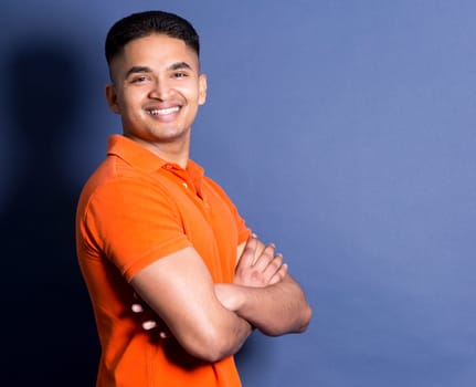 young casual man wearing orange tshirt on blue background