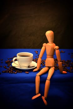 Withe Coffee cup and coffee beans with wooden figure on wooden table