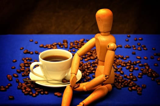 Withe Coffee cup and coffee beans with wooden figure on wooden table