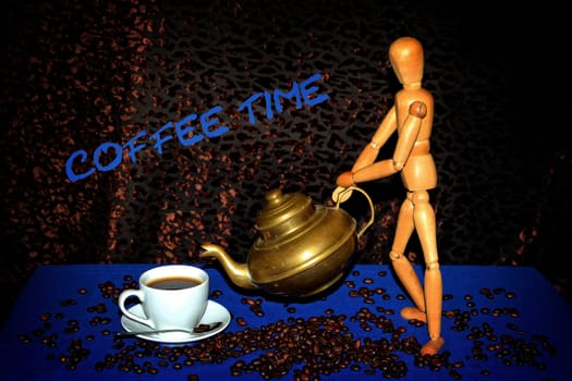 Wooden doll gives with golden coffee pot coffee in white cup,stands on coffee beans on blue tablecloth against a dark background with lettering coffee time