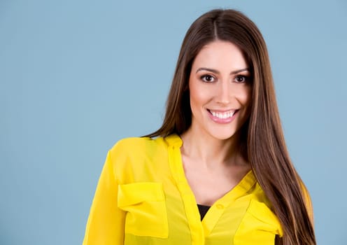 young woman wearing yellow shirt on blue background