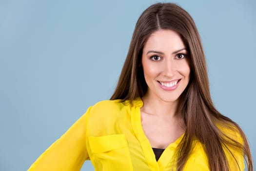 young woman wearing yellow shirt on blue background