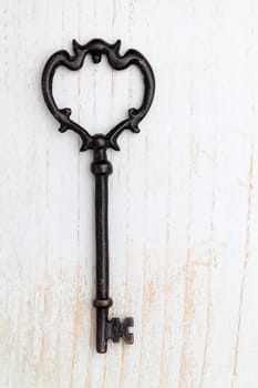 Antique key on white wood background