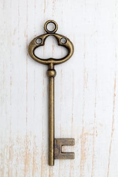 Antique rusty key on wood background