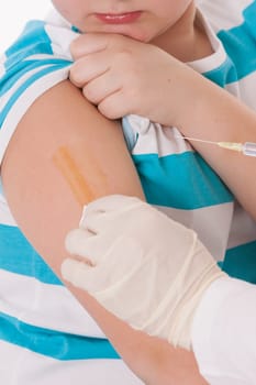 Doctor giving a child injection in arm on isolated image.