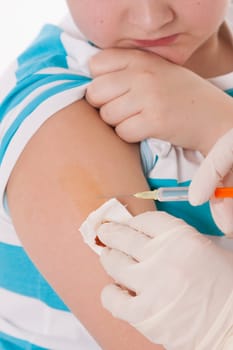 Doctor giving a child injection in arm on isolated image.