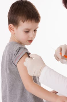 Doctor giving a child injection in arm on isolated image.