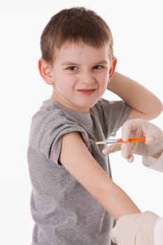Doctor giving a child injection in arm on isolated image.