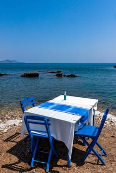 Tables with chairs in traditional Greek tavern in Kolympia town on coast of Rhodes island, Greece.