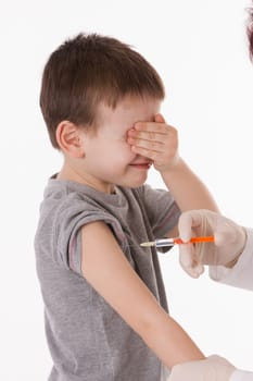 Doctor giving a child injection in arm on isolated image.