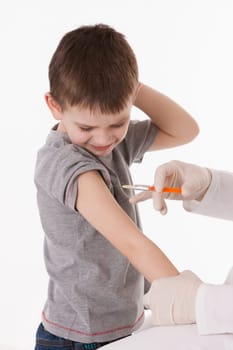 Doctor giving a child injection in arm on isolated image.