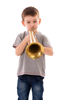 young boy blowing into a trumpet against white background