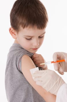 Doctor giving a child injection in arm on isolated image.