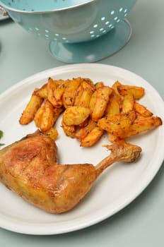 Roasted chicken with potato wedges on a plate