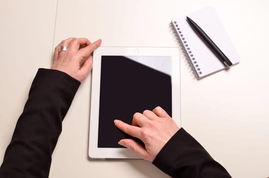 businesswoman on an office table with a tablet computer and a notebook