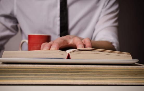 Business man reading a big book on a tablet computer