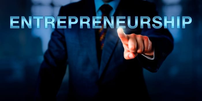 Innovator is touching ENTREPRENEURSHIP on a virtual screen. business metaphor and concept for a positive attitude towards risk-taking and the process of launching and developing a new business.
