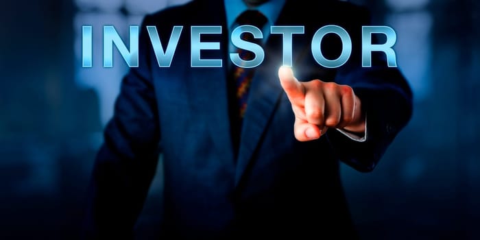 Corporate executive is pressing INVESTOR on a touch screen interface. Business metaphor and financial concept for a business professional leveraging capital for a future financial gain..