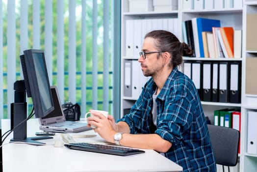 creative man is working in his office and drinking coffee