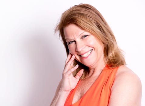 middle aged woman wearing orange dress on white background